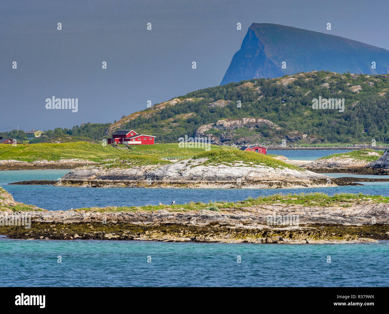 Island Kvalöy, red house on small island, seen from  Ferry Botnham - Kvalöya, west of Tromsö, Troms, Norway Stock Photo