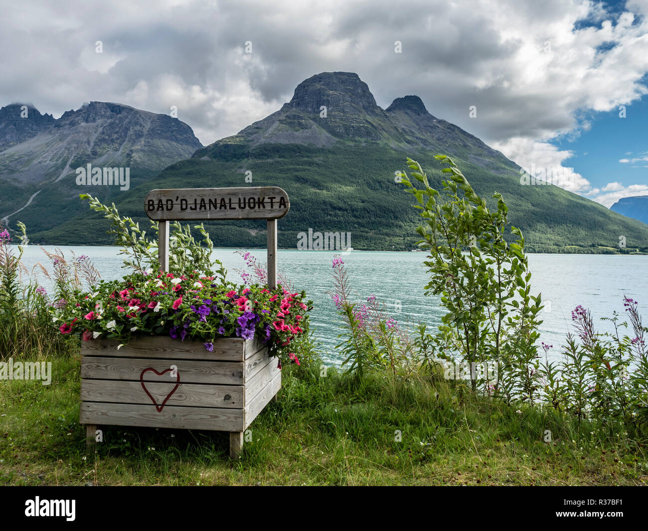 Rest area at fjord Storfjord, wooden flower box with painted red heart,  view to mountain Hatten, moutain range Hattefjellet,  Lyngen, view to main la Stock Photo