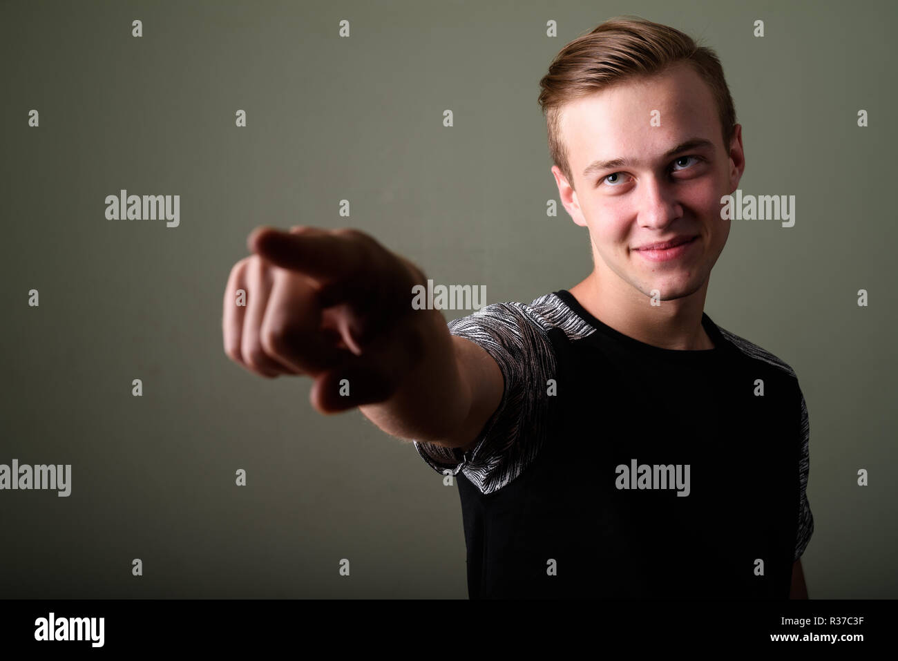Young handsome man with blond hair against colored background Stock Photo