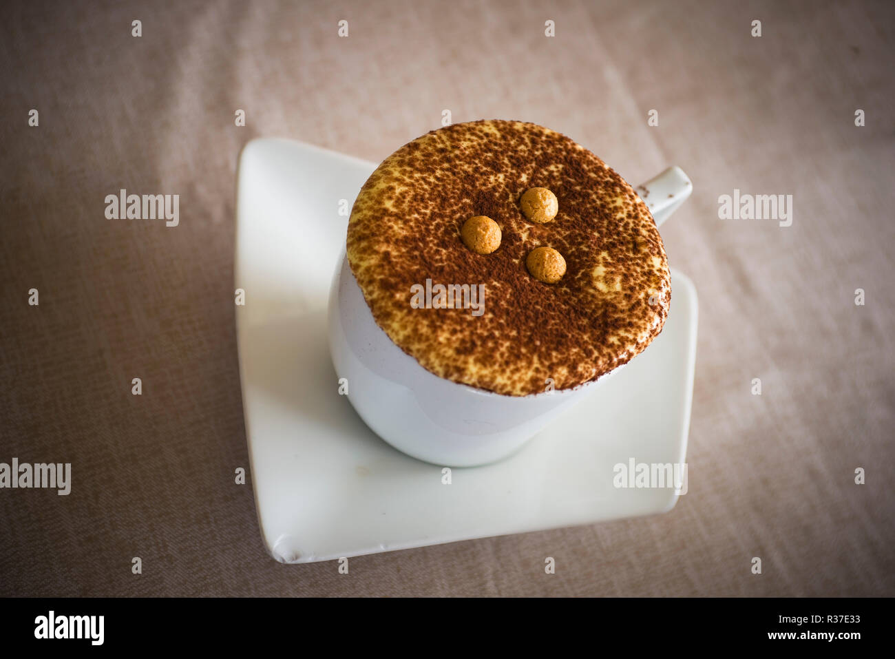 Cup of cappuccino coffee with cacao topping and cookie pearls. Varenna, Province of Lecco, Lombardy, Italy, Europe Stock Photo