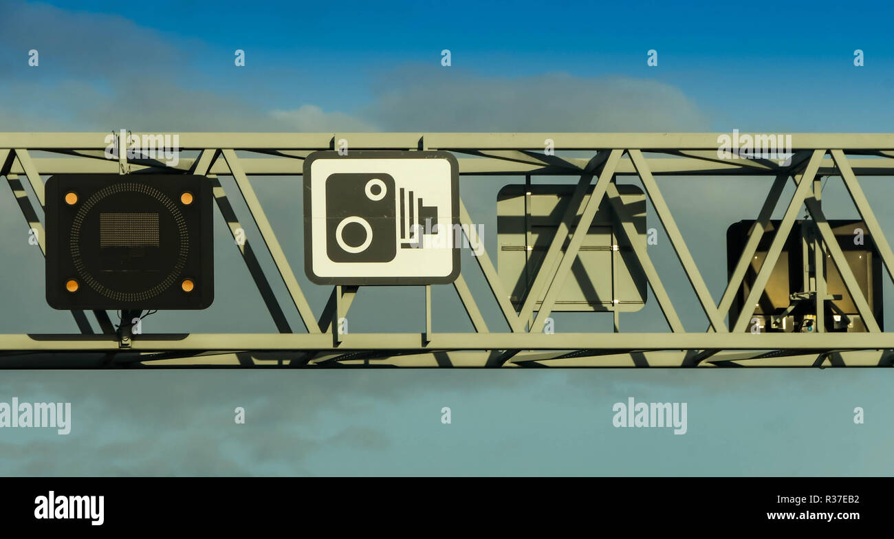 BRISTOL, ENGLAND - NOVEMBER 2018: Close up view of a gantry above the M4 motorway near Bristol. The sign shows traffic cameras are used to enforce spe Stock Photo