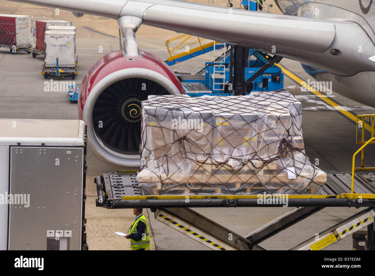 LONDON HEATHROW AIRPORT - JUNE 2018: Close up of an air freight pallet being loaded into the cargo hold of a Virgin Atlantic Airbus A330 at London Stock Photo