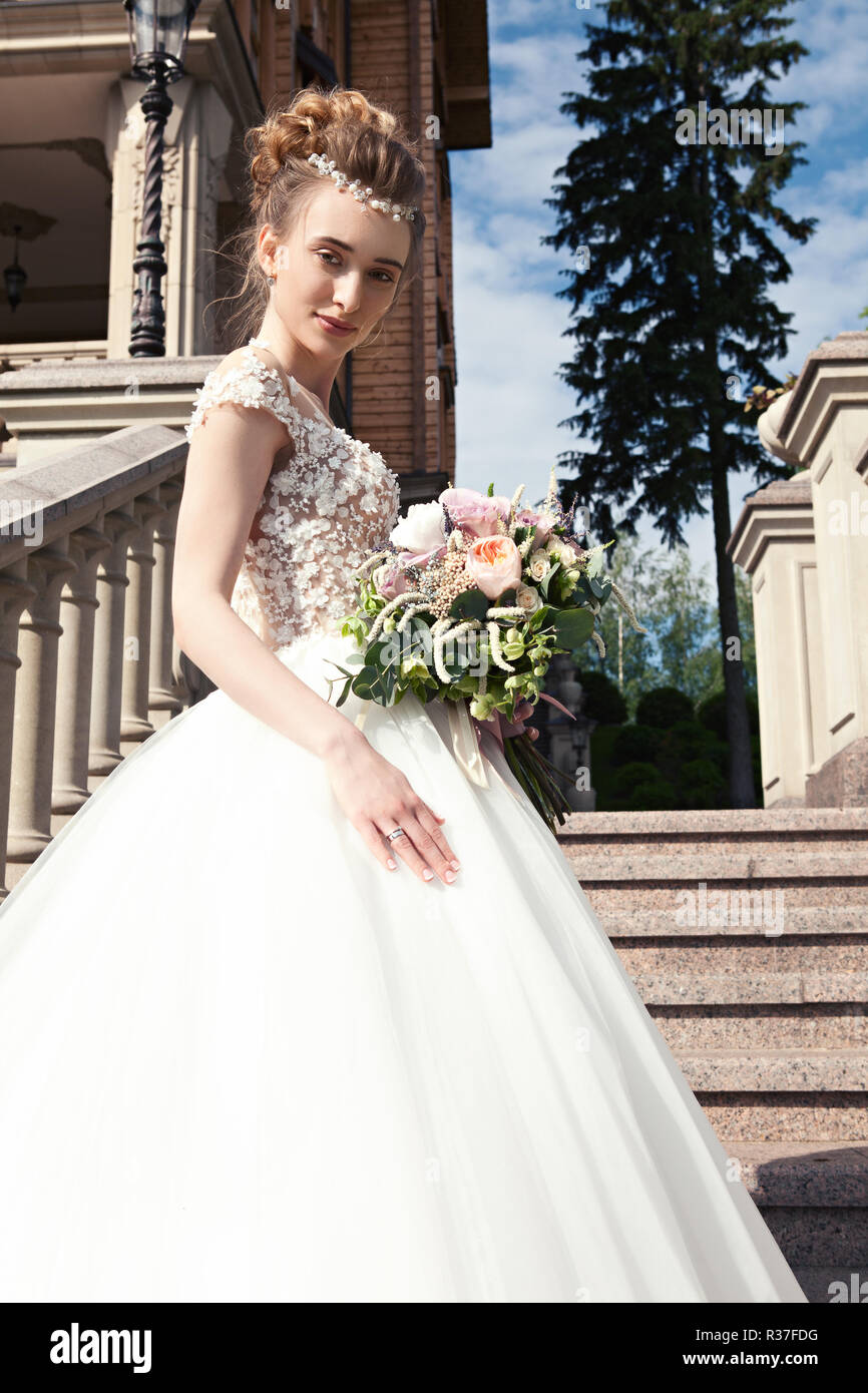 Bride in a white dress with a beautiful wedding bouquet on a marble ...