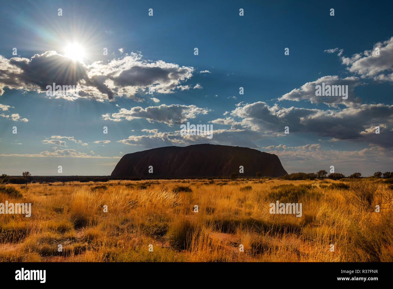 The sun is shining over Uluru. Stock Photo