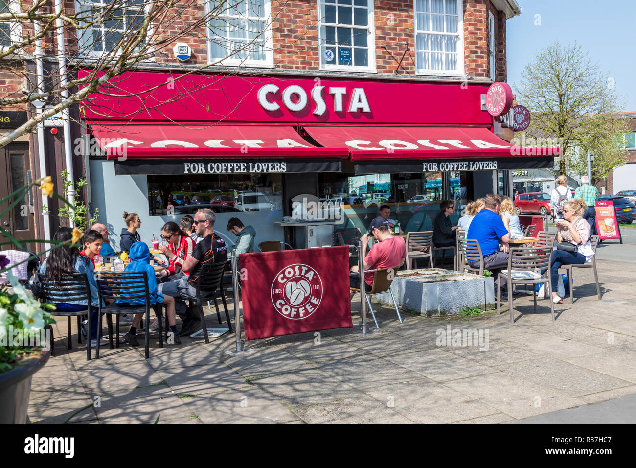 Costa coffee shop in Wilmslow, Customers are sitting outside eating and drinking on a sunday spring day. Stock Photo