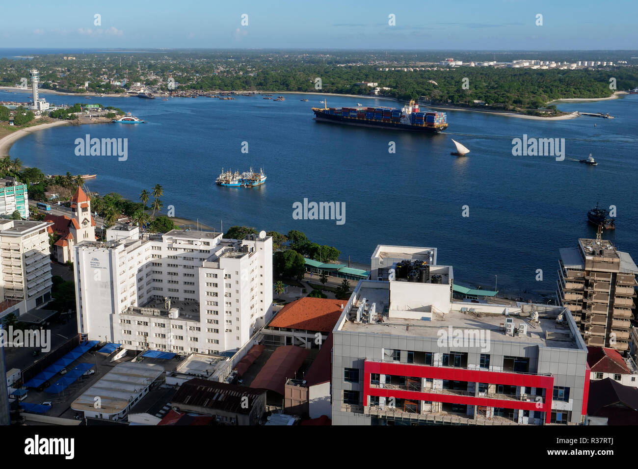 TANZANIA Daressalaam, bay and seaport, Pacific International Lines PIL container ship sailing to indian ocean, in front protestant Azania Front cathedral, built during german colonial time Stock Photo