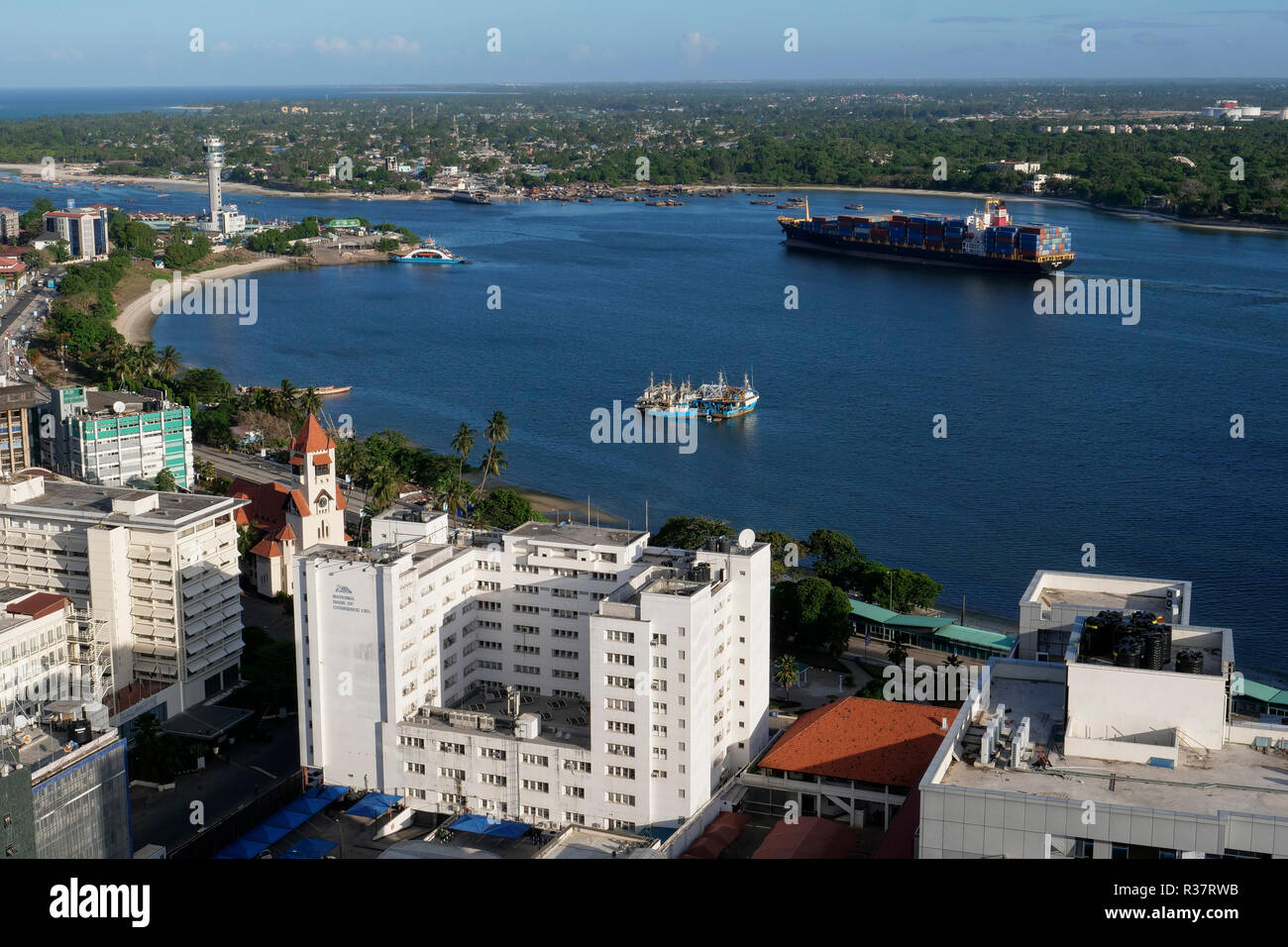 TANZANIA Daressalaam, bay and seaport, PIL container ship sailing to indian ocean, in front protestant Azania Front cathedral, built during german colonial time Stock Photo