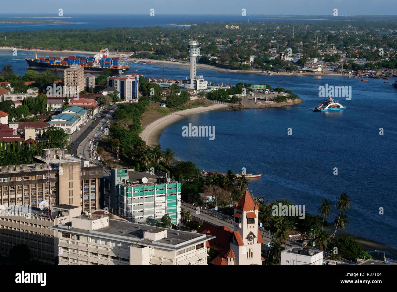 TANZANIA Daressalaam, bay and seaport, PIL container ship sailing to indian ocean, in front protestant Azania Front cathedral, built during german colonial time, Kigamboni Ferry Terminal Stock Photo