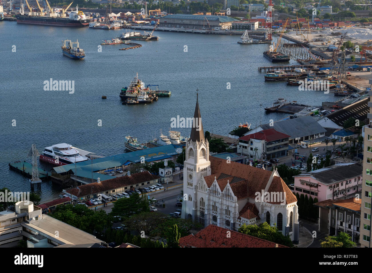 TANZANIA Daressalaam, bay and seaport, in front catholic St. Joseph cathedral, built during german colonial time, and passenger ferry terminal Stock Photo