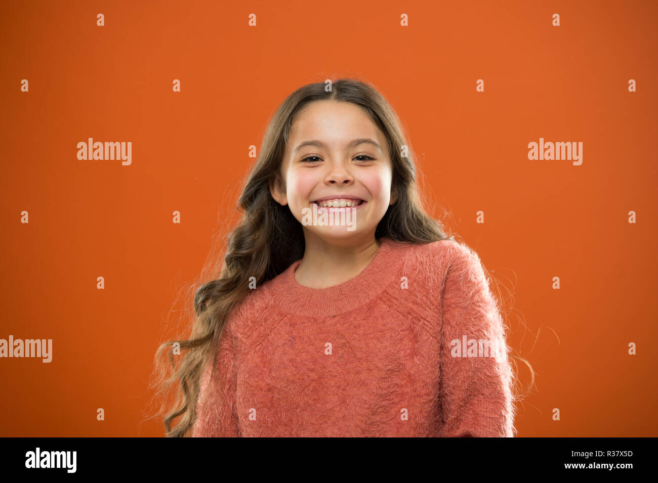 What is difference between phony and sincere smile. Girl cute child happy smiling face. What science has to say about genuine and fake smiles. Child long hair happy smiling. Happy childhood concept. Stock Photo