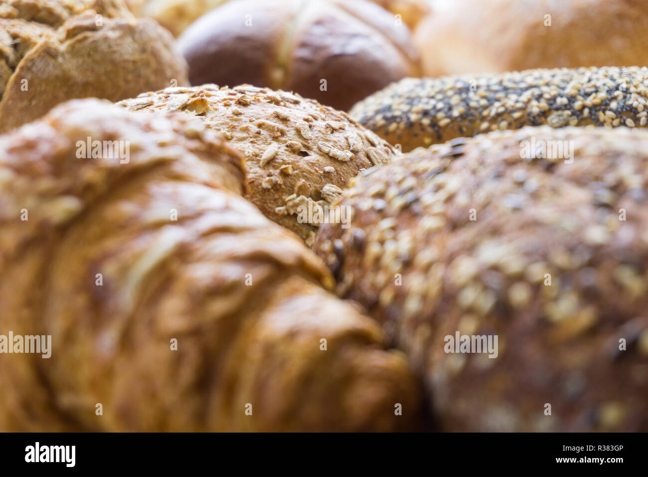 Close-up of Mixed Bread and baked Bread rolls usable as decorative Food Background. Freshly baked Whole-grain Bread Rolls with Sesame Seeds. Stock Photo