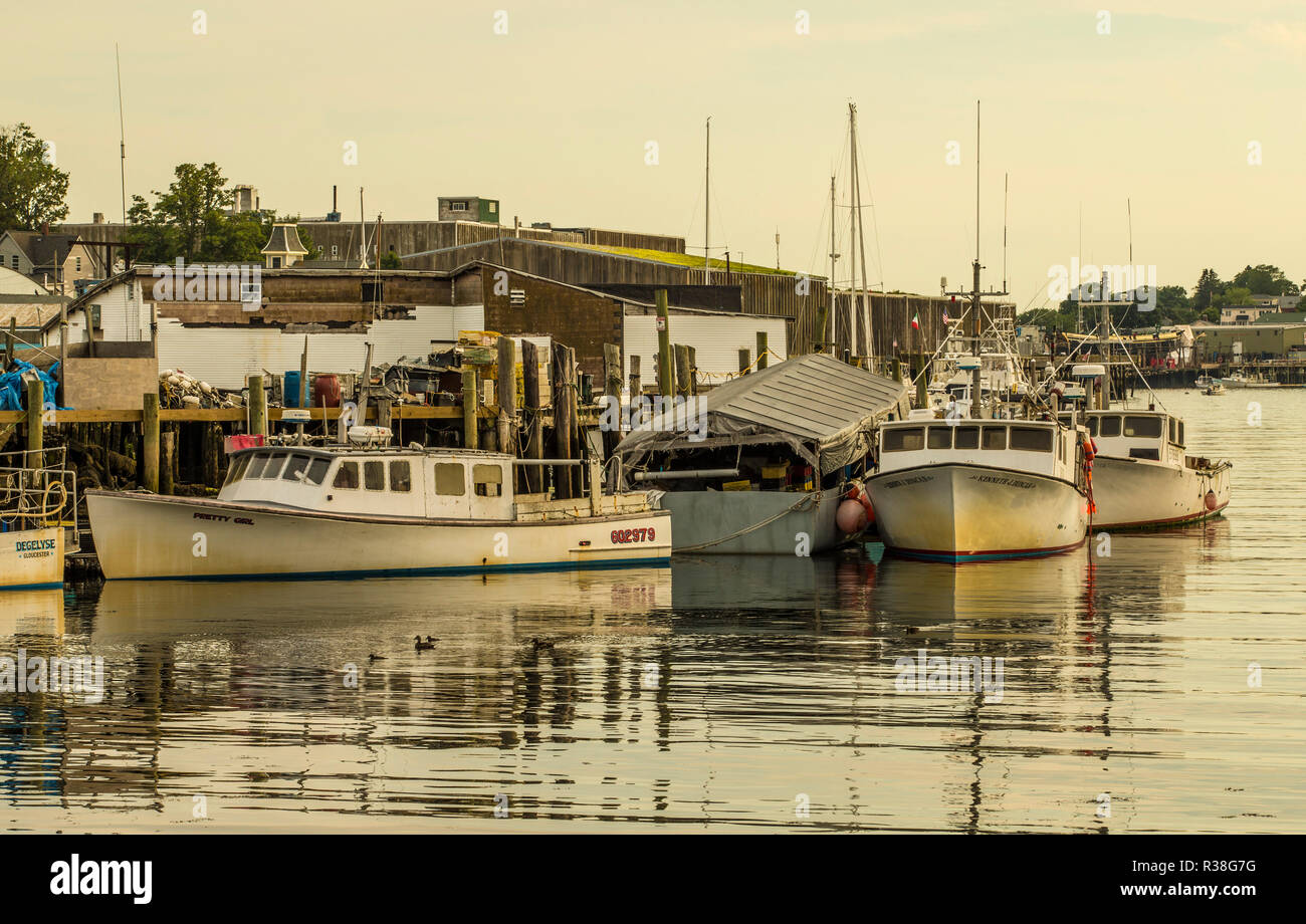 Boats in Rocky Neck, Gloucester, Mass. On rocky peninsula within working harbor there's a boat repair building, artist's colony and residential homes. Stock Photo