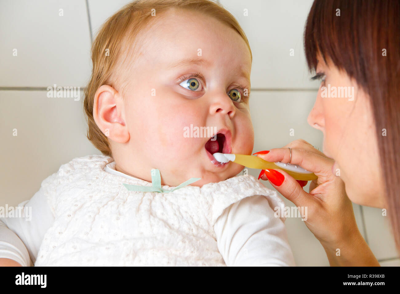 mama brushing teeth of her baby Stock Photo