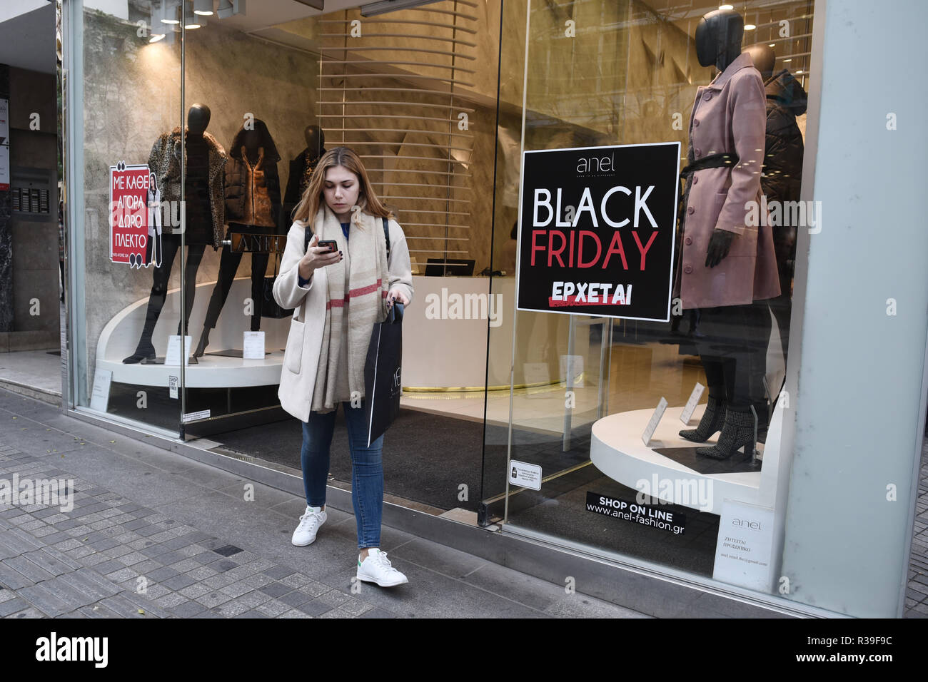 November 22, 2018 - Thessaloniki, Greece - A woman exits from a clothes  shop at the center of the city. Shops in Thessaloniki are getting ready for  tomorrow's Black Friday deals. (Credit
