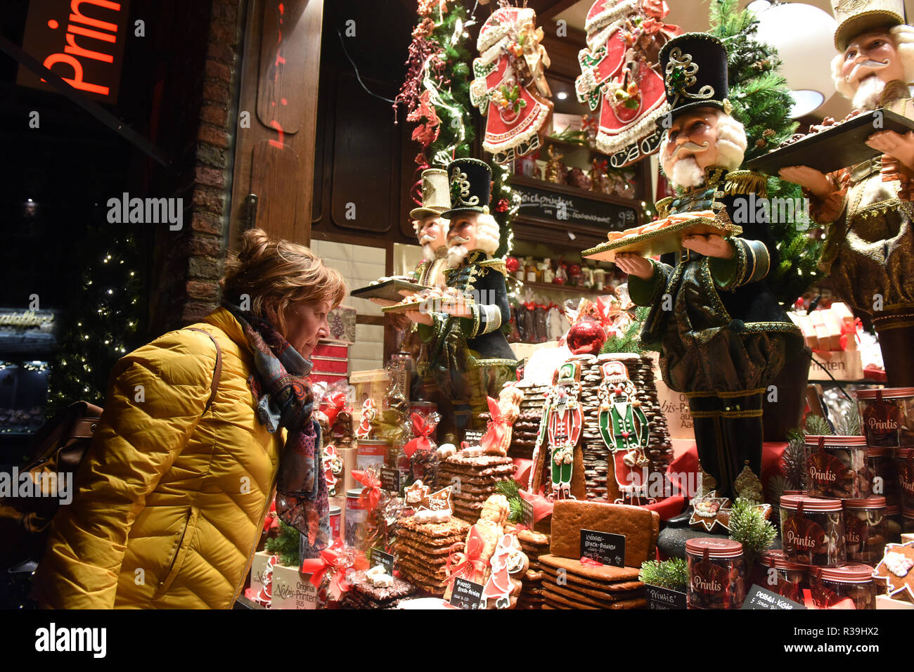 Aachen, Germany. 22nd Nov 2018. Christmas window decorations unveiled for  the German Christmas market which opens tomorrow in Aachen Germany Europe.  This Christmas shopper is looking at the Nobis Printen confectionary shop.