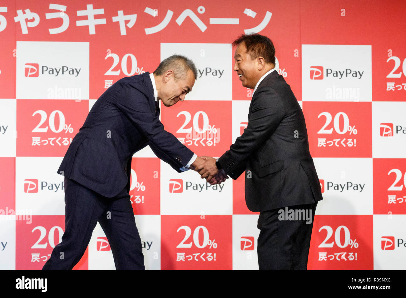 (L to R) Ichiro Nakayama, president and CEO of PayPay Corp. shake hands with Jun Shimba representative director and COO of SoftBank Corp., during a news conference to announce the new smartphone payment service ''PayPay'' on November 22, 2018, Tokyo, Japan. PayPay is a smartphone payment service using barcodes (QR codes) supported by SoftBank, Yahoo Japan and Paytm, that can be used in Japanese stores including Bic Camera, Yamada Denki and Family Mart. Credit: Rodrigo Reyes Marin/AFLO/Alamy Live News Stock Photo