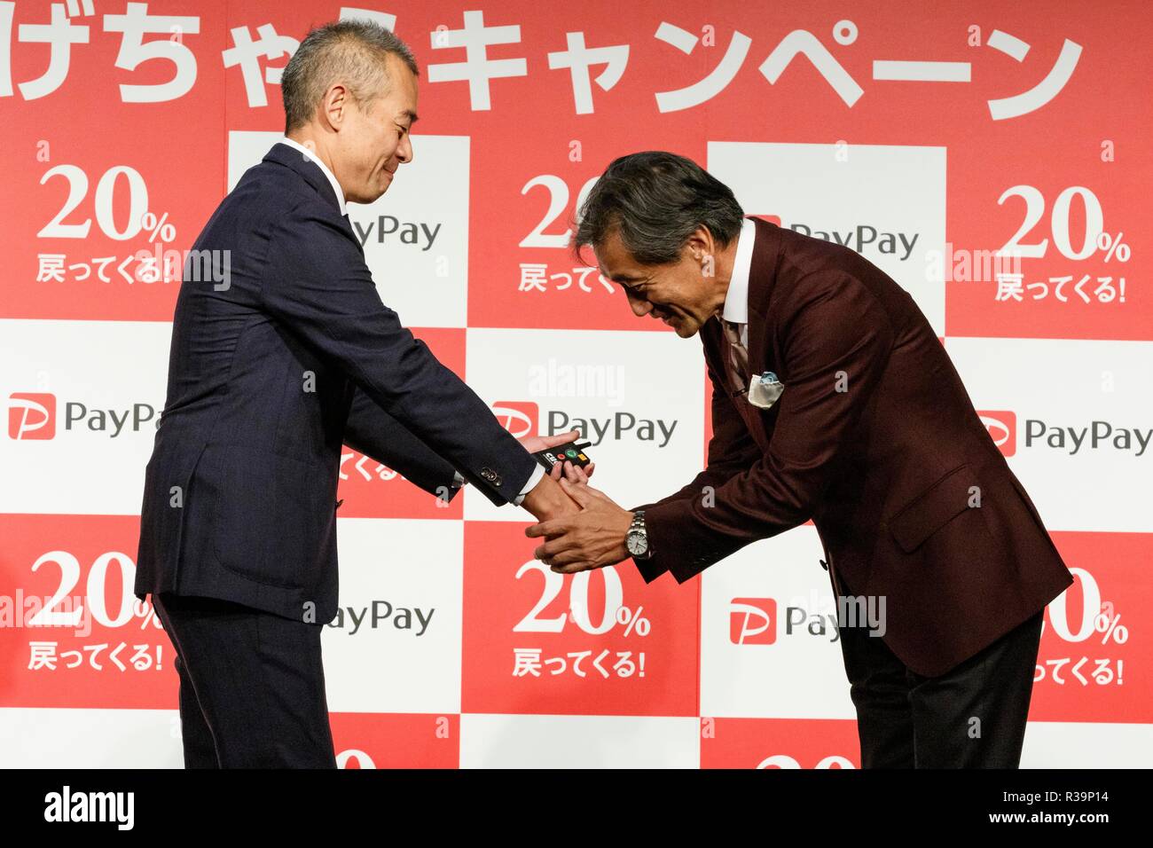 (L to R) Ichiro Nakayama, president and CEO of PayPay Corp. shake hands with Takashi Sawada president of Japan's convenience store FamilyMart, during a news conference to announce the new smartphone payment service ''PayPay'' on November 22, 2018, Tokyo, Japan. PayPay is a smartphone payment service using barcodes (QR codes) supported by SoftBank, Yahoo Japan and Paytm, that can be used in Japanese stores including Bic Camera, Yamada Denki and Family Mart. Credit: Rodrigo Reyes Marin/AFLO/Alamy Live News Stock Photo