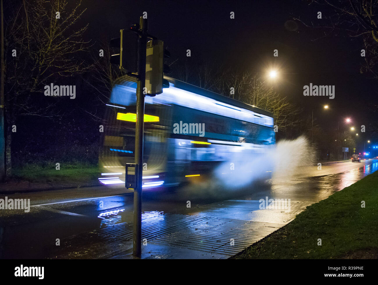 Carrigaline, Cork, Ireland. 23rd November, 2018. Early morning traffic pass through a section of flooded road after a night of heavy rain at Bothar Guidel, Carrigaline, Co. Cork. Stock Photo