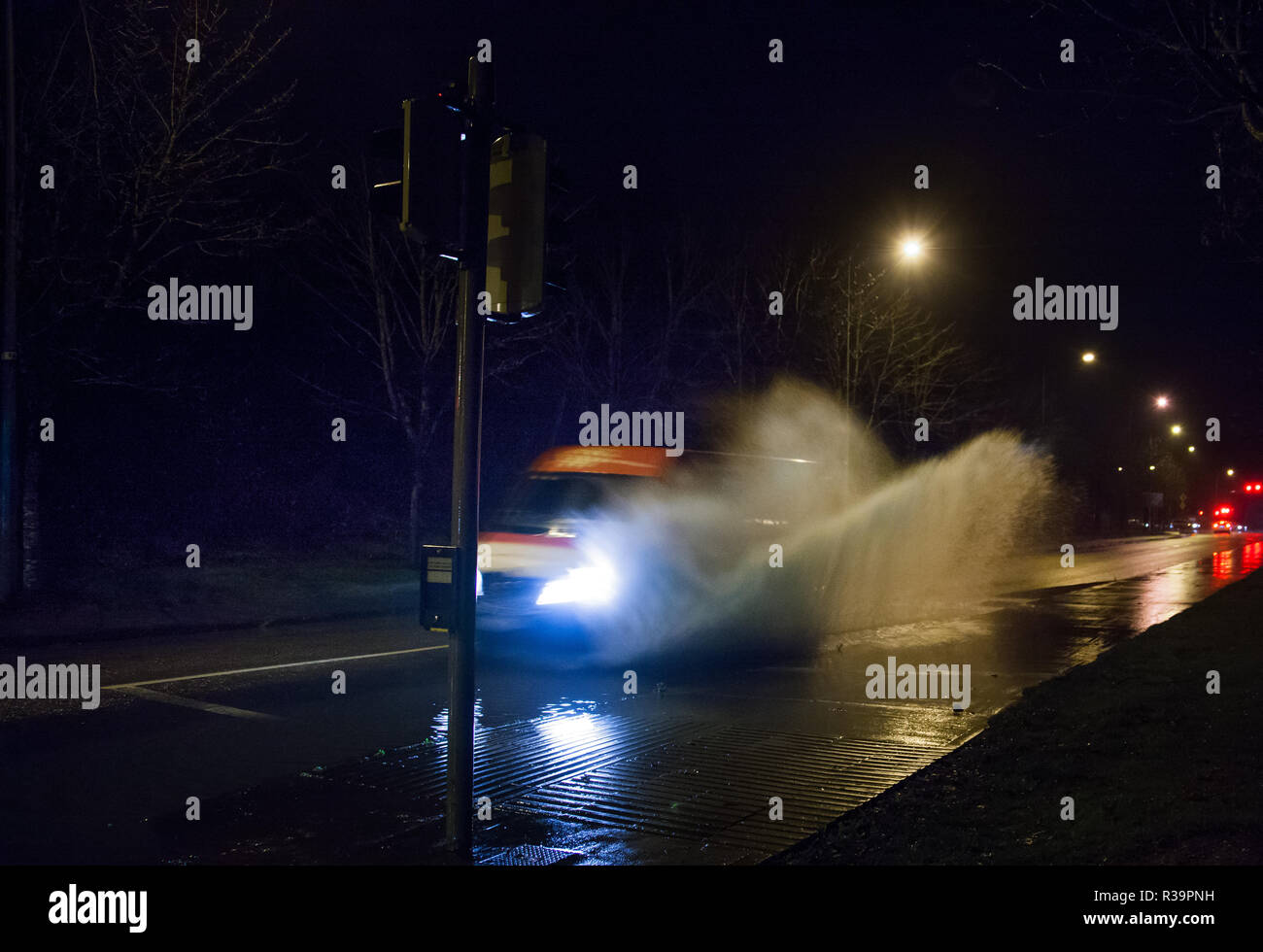 Carrigaline, Cork, Ireland. 23rd November, 2018. Early morning traffic pass through a section of flooded road after a night of heavy rain at Bothar Guidel, Carrigaline, Co. Cork. Stock Photo