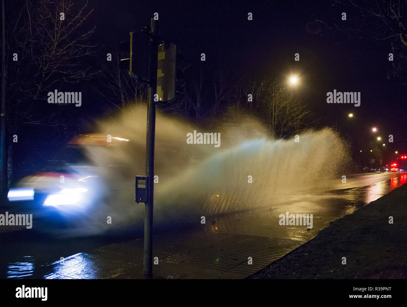 Carrigaline, Cork, Ireland. 23rd November, 2018. Early morning traffic pass through a section of flooded road after a night of heavy rain at Bothar Guidel, Carrigaline, Co. Cork. Stock Photo