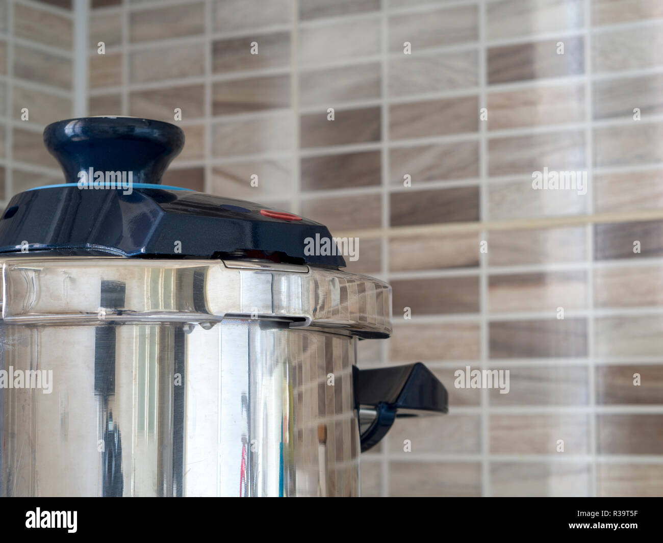 metallic steel pressure cooker standing on oven in kitchen Stock Photo