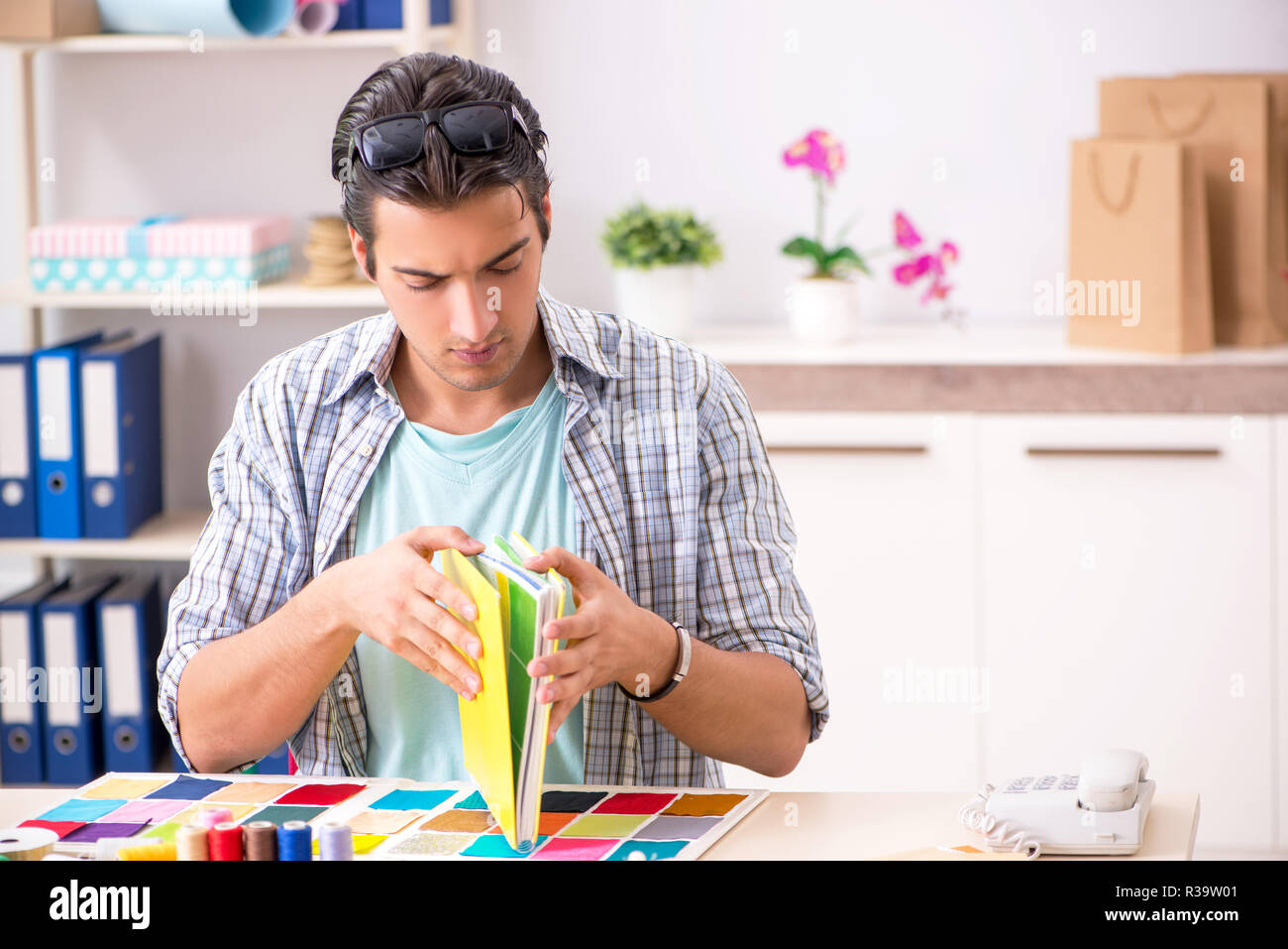 Young handsome tailor working in his workshop Stock Photo - Alamy