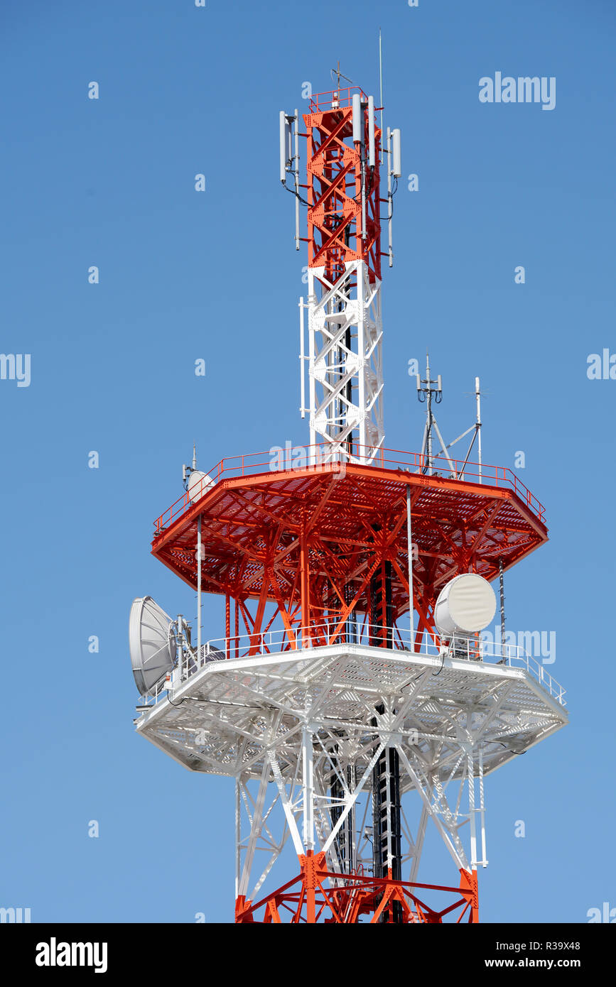 View of communication tower with antenna against blue sky Stock Photo