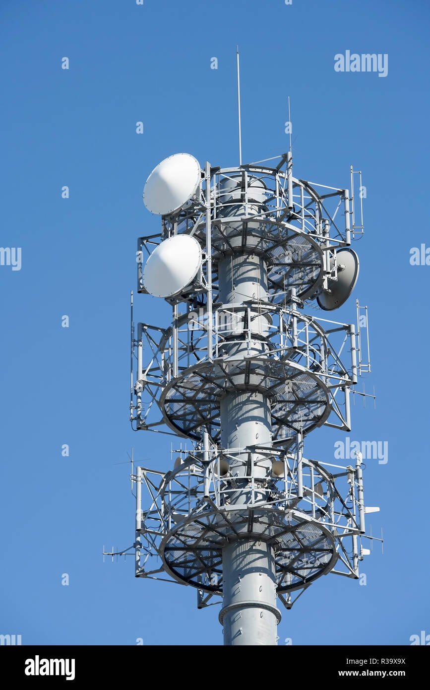 View of communication tower with antenna against blue sky Stock Photo