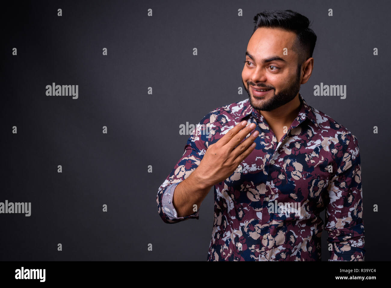 Young bearded Indian man against gray background Stock Photo