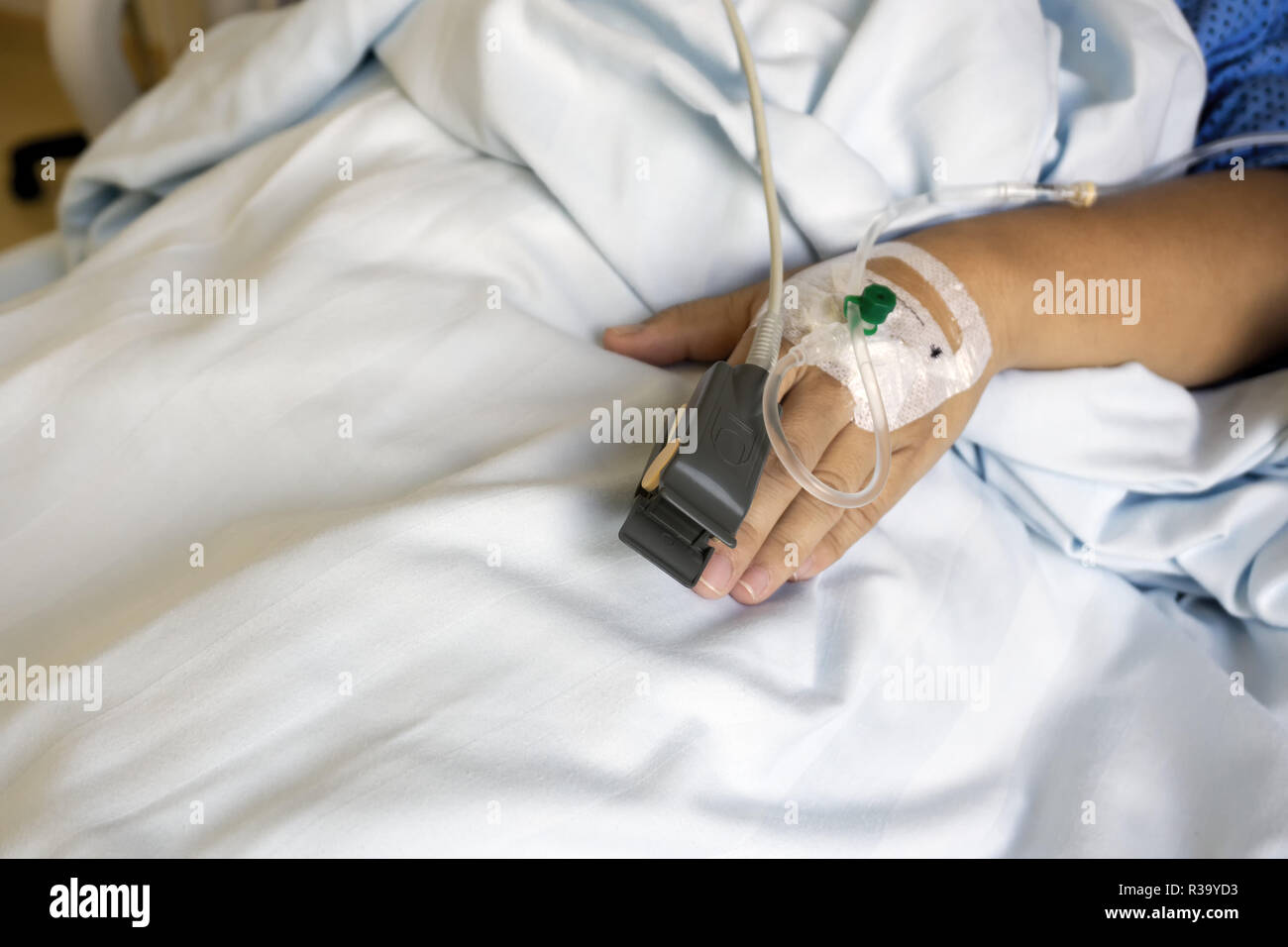 SpO2 Sensor (peripheral capillary oxygen saturation) and Iv Drip on Patient Hands at the Hospital Room. Stock Photo