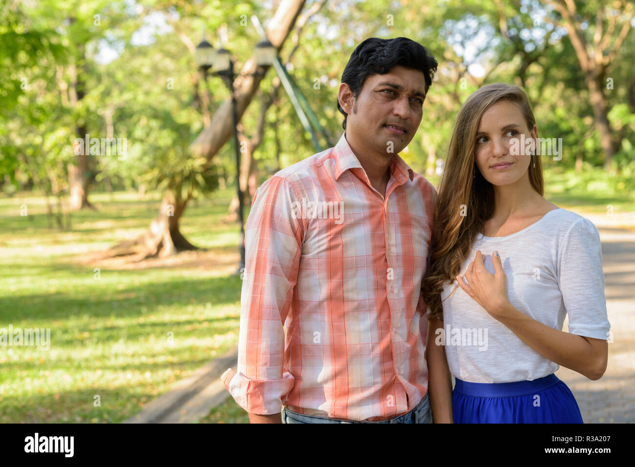 Multi ethnic couple thinking while looking at distance and in lo Stock Photo