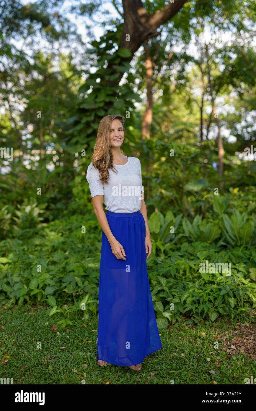 Full body shot of happy beautiful woman smiling while standing a Stock Photo