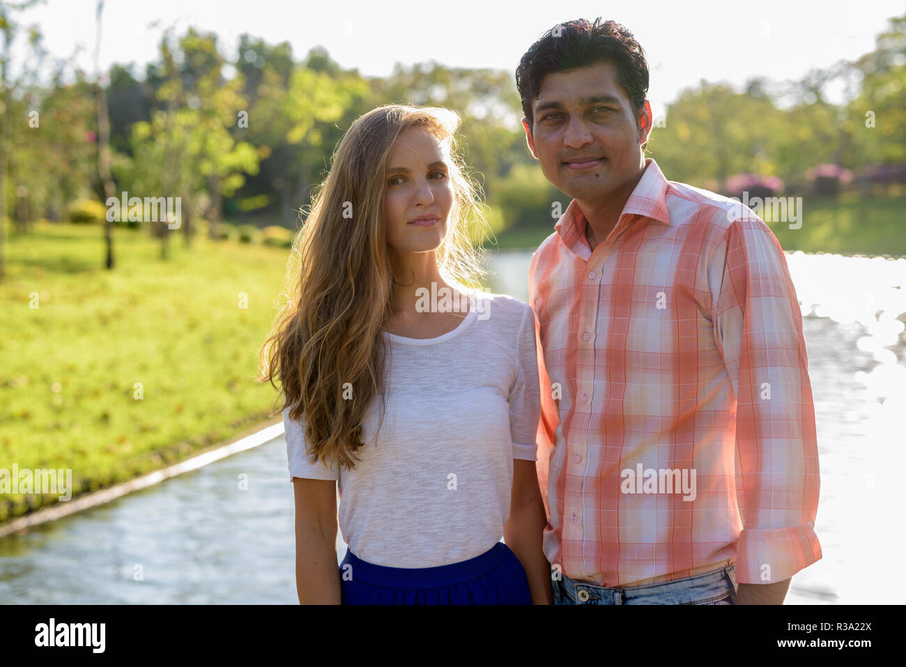 Multi ethnic couple in love against beautiful view of the lake a Stock Photo