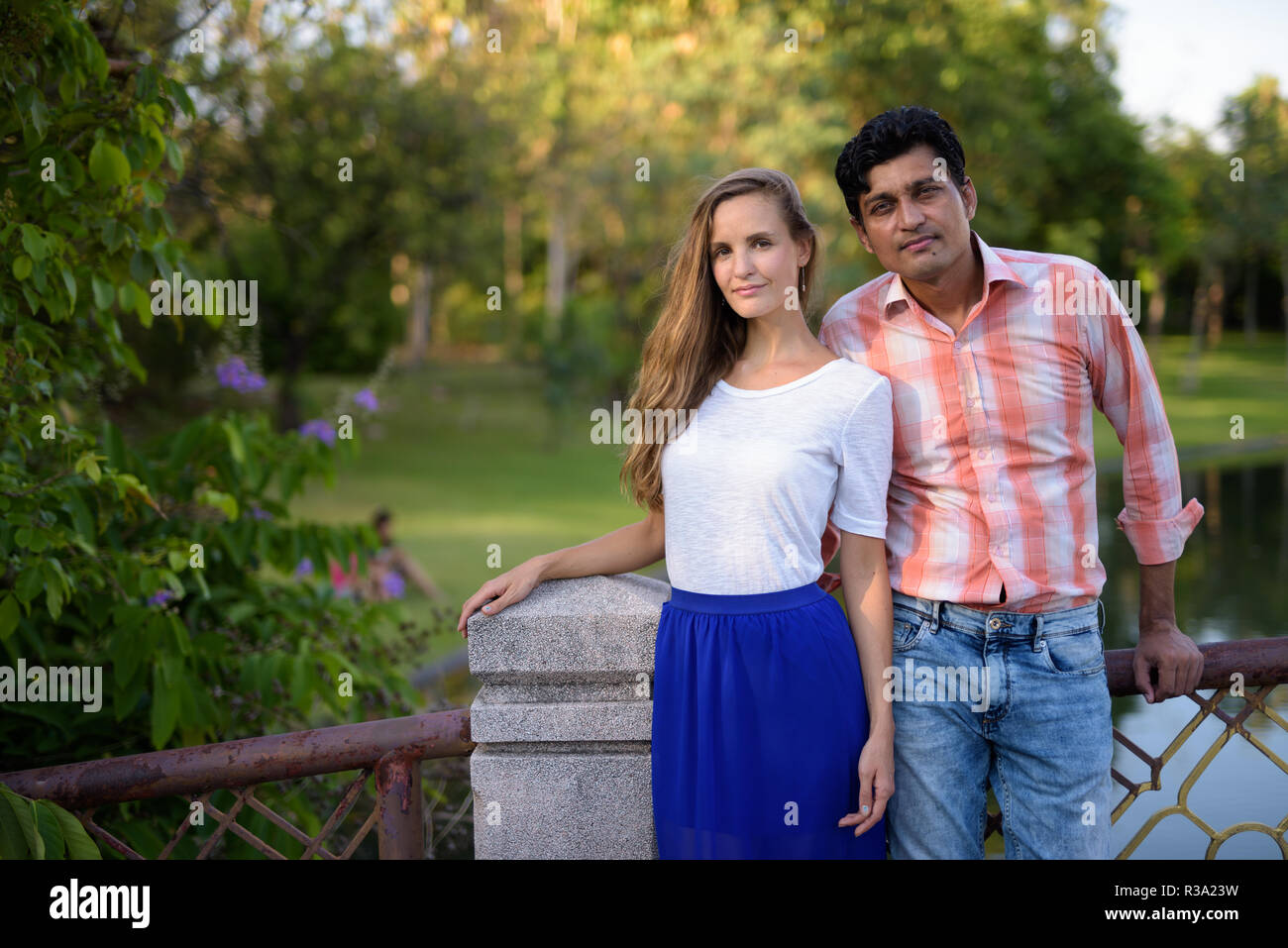 Multi ethnic couple standing together on the bridge of peaceful  Stock Photo