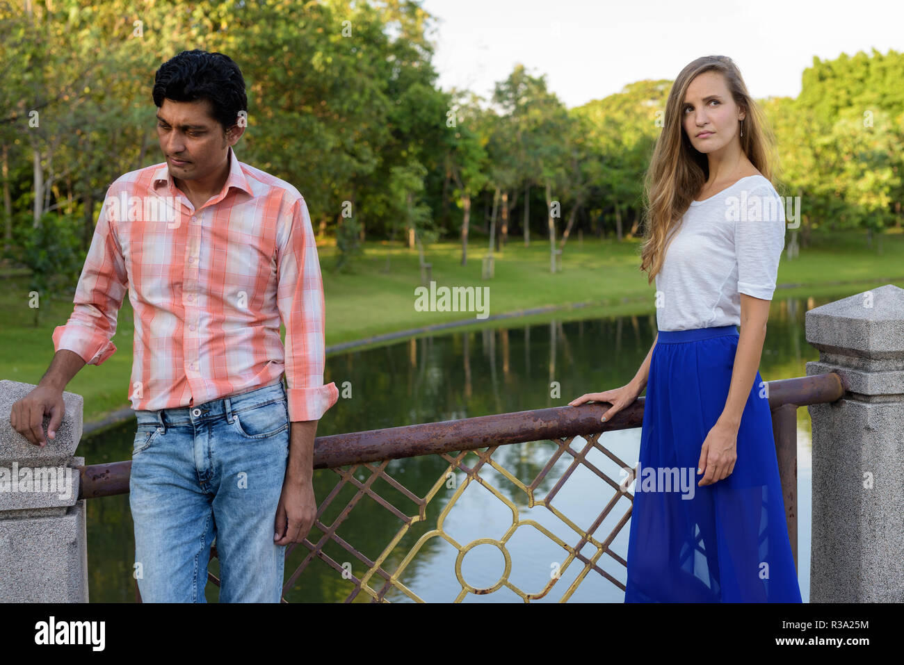 Multi ethnic couple thinking and looking away from each other on Stock Photo