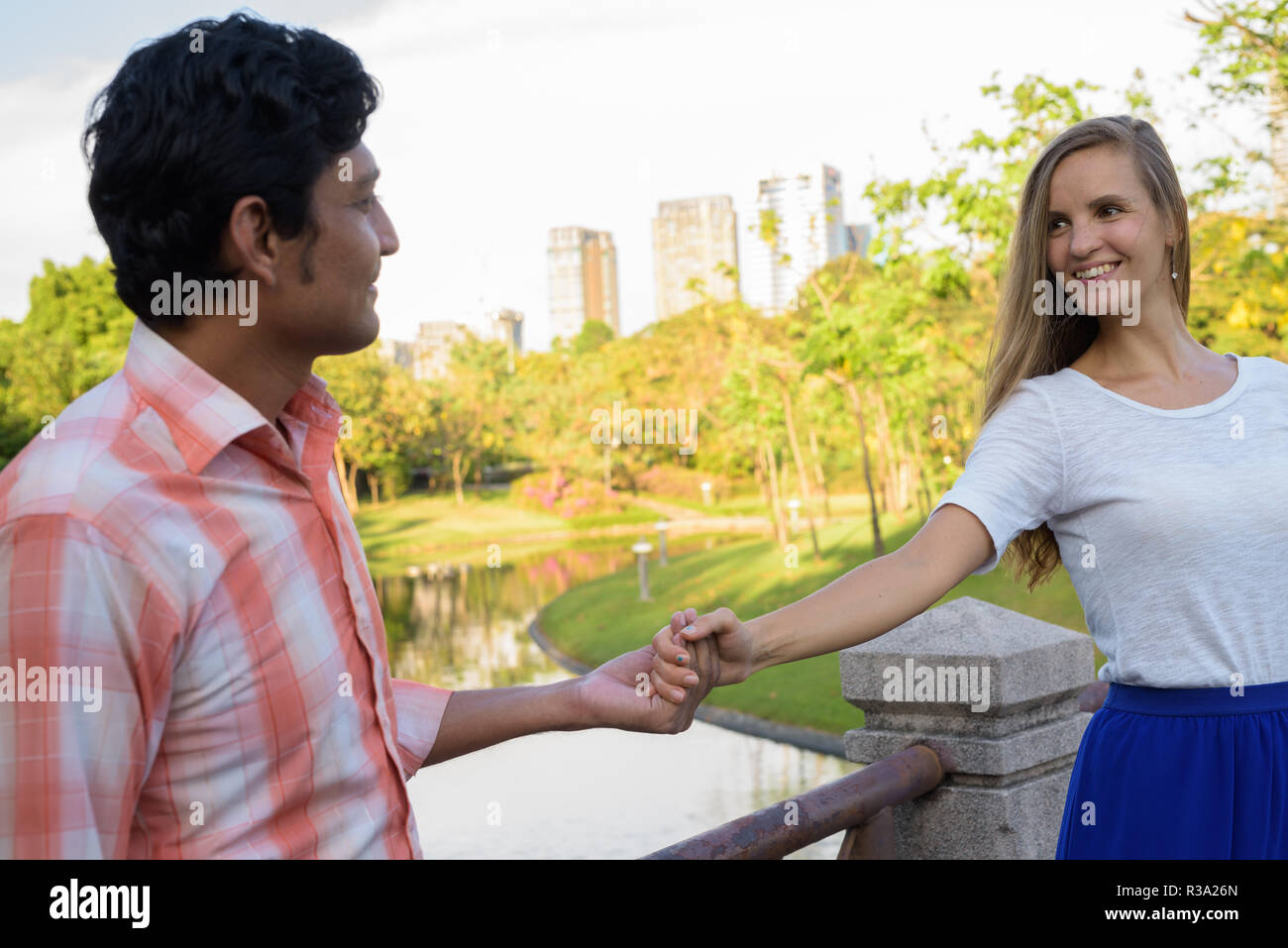 Happy multi ethnic couple smiling while looking at each other an Stock Photo