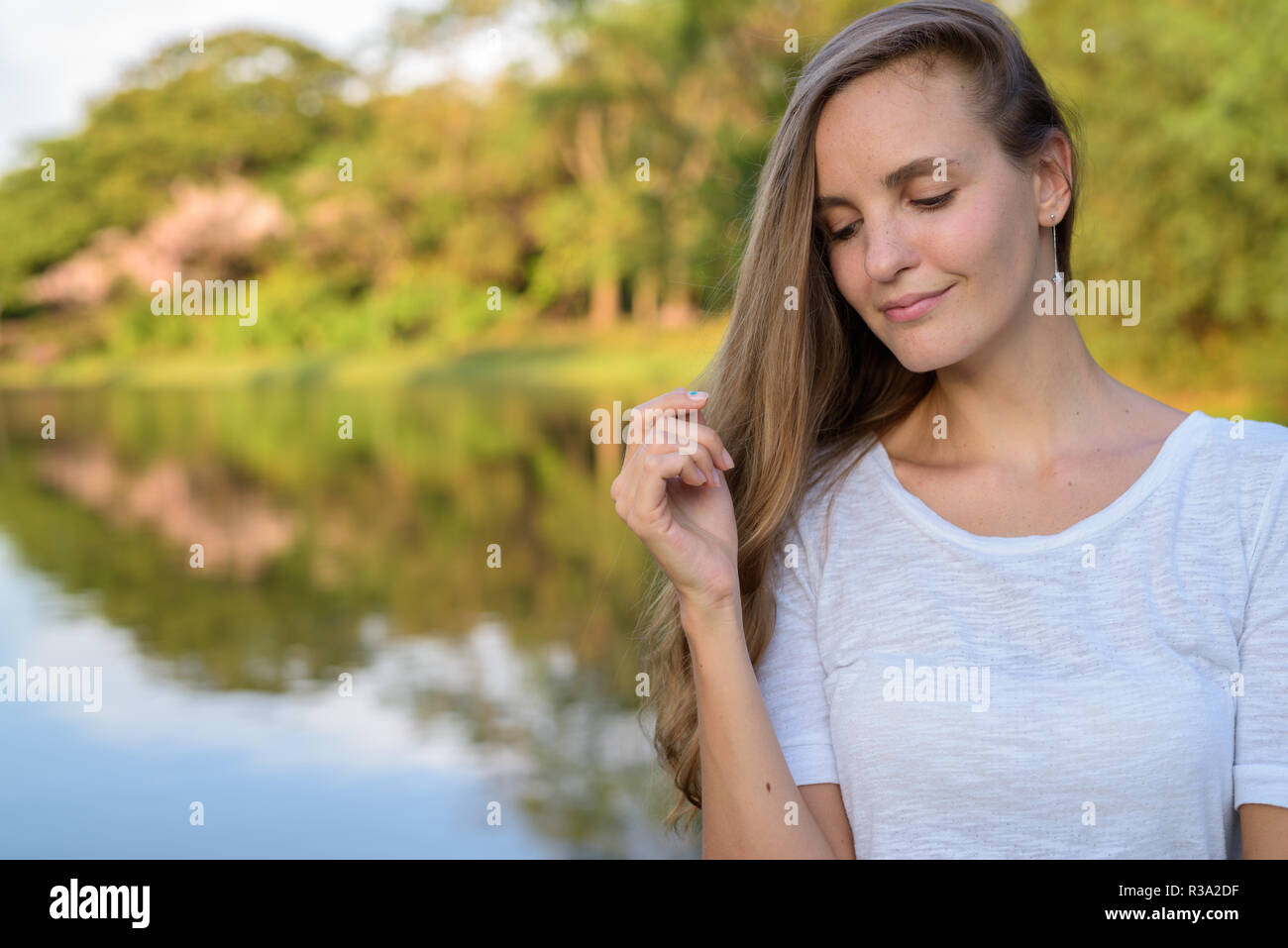 Close up of beautiful woman with long hair thinking against scen Stock Photo