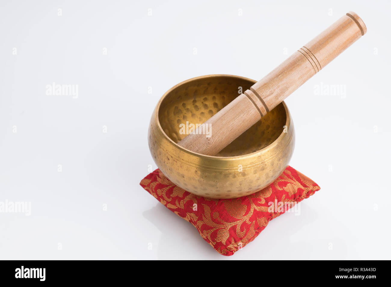 Tibetan Singing Bowl on Red Cushion Isolated on White Background Stock Photo