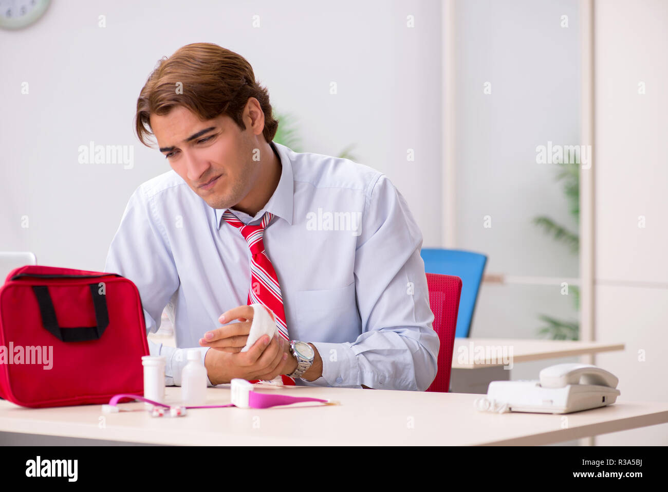 Man with first aid kit in the office Stock Photo - Alamy