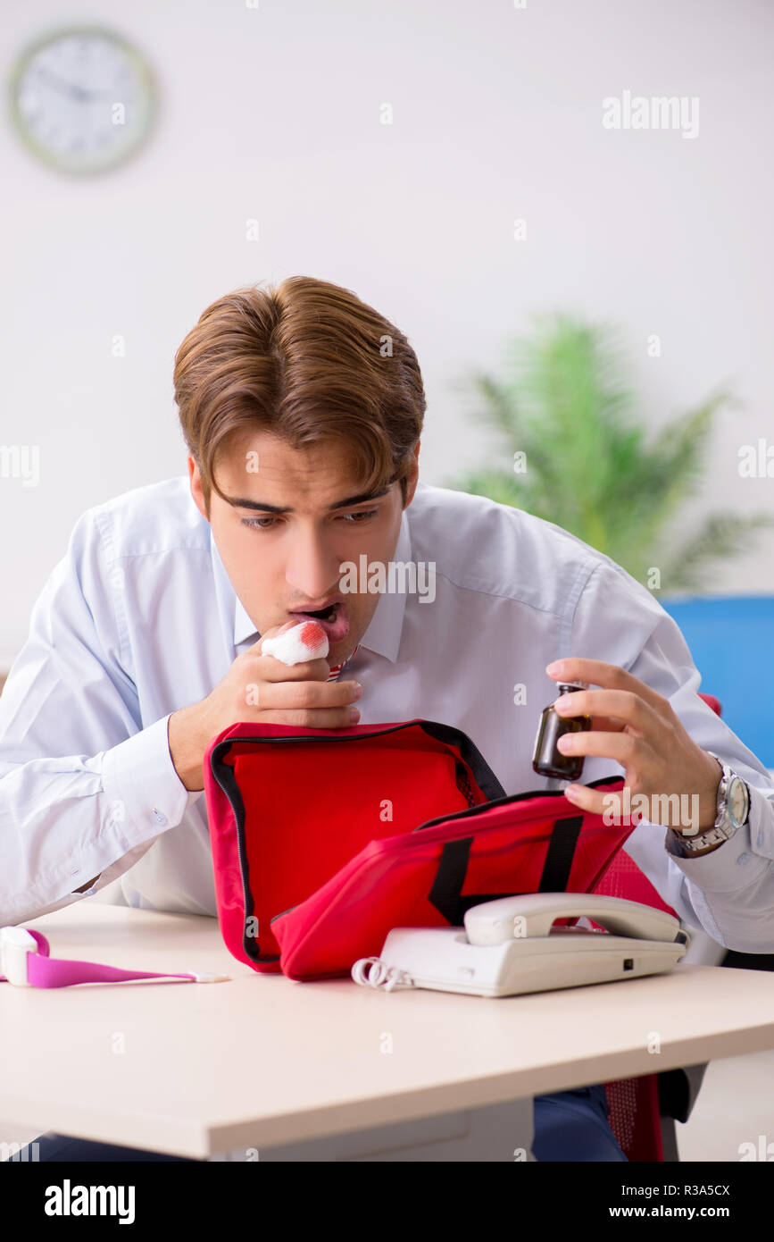 Man with first aid kit in the office Stock Photo - Alamy