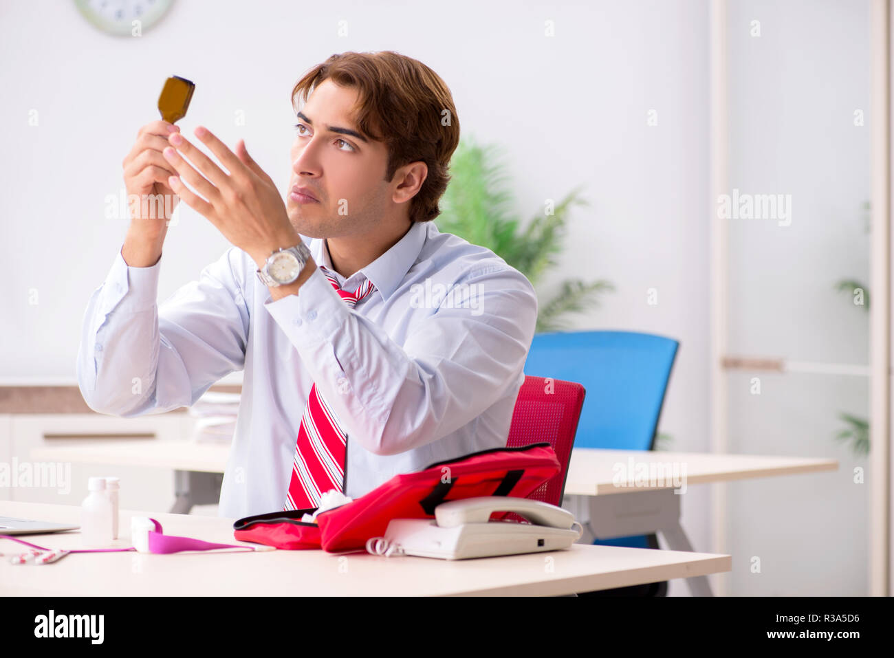 Man with first aid kit in the office Stock Photo - Alamy