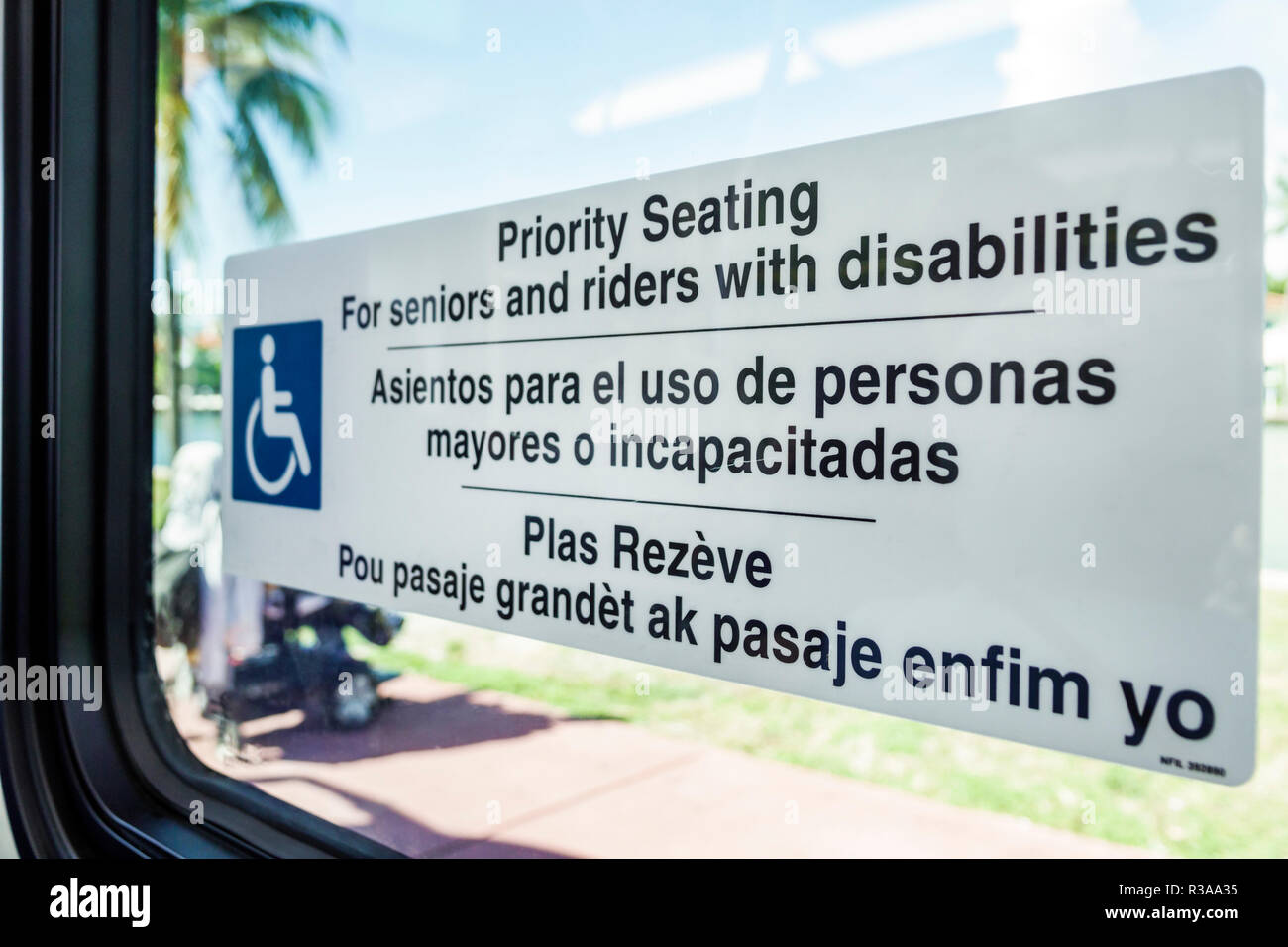Miami Beach Florida,Miami-Dade Metrobus sign bilingual Spanish English Creole languages,priority seating seniors disabilities,FL181115023 Stock Photo