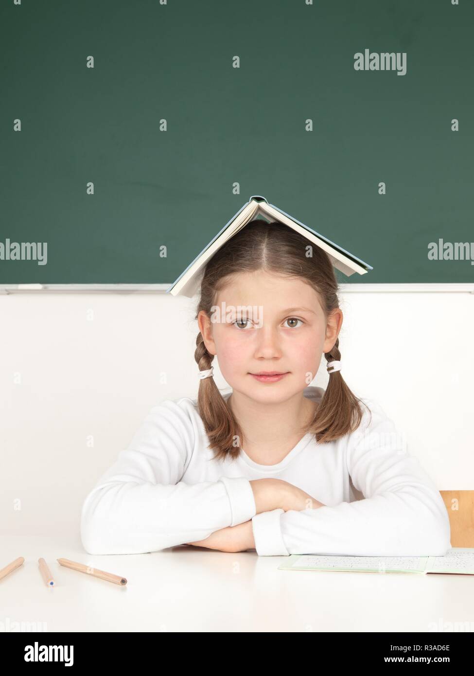schoolgirl holding her book on her head Stock Photo - Alamy