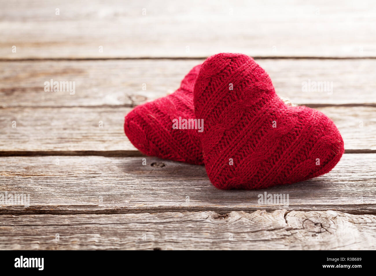 Valentines day greeting card with red heart toys on wooden table. With ...