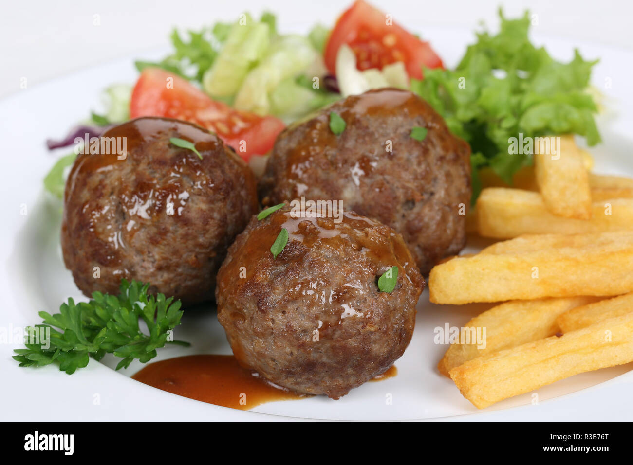 meatballs or meatballs dish with fries and salad Stock Photo