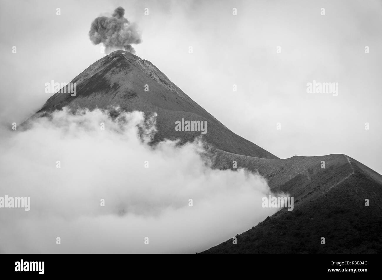 Eruption of volcano Fuego in cloudy and misty weather. Black and white photo. Stock Photo