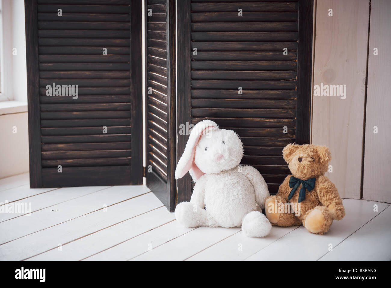 Two enamored teddy toys bear and bunny sitting next to Stock Photo
