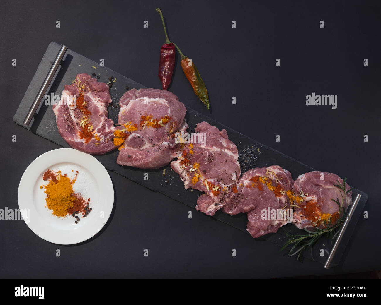 Sliced and spiced pork meat  for barbecue on black background Stock Photo