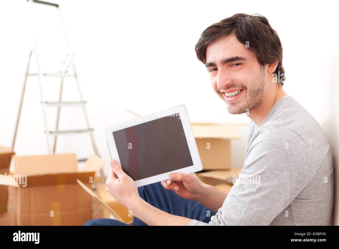 Handsome man tablet checking boxes hi-res stock photography and images ...