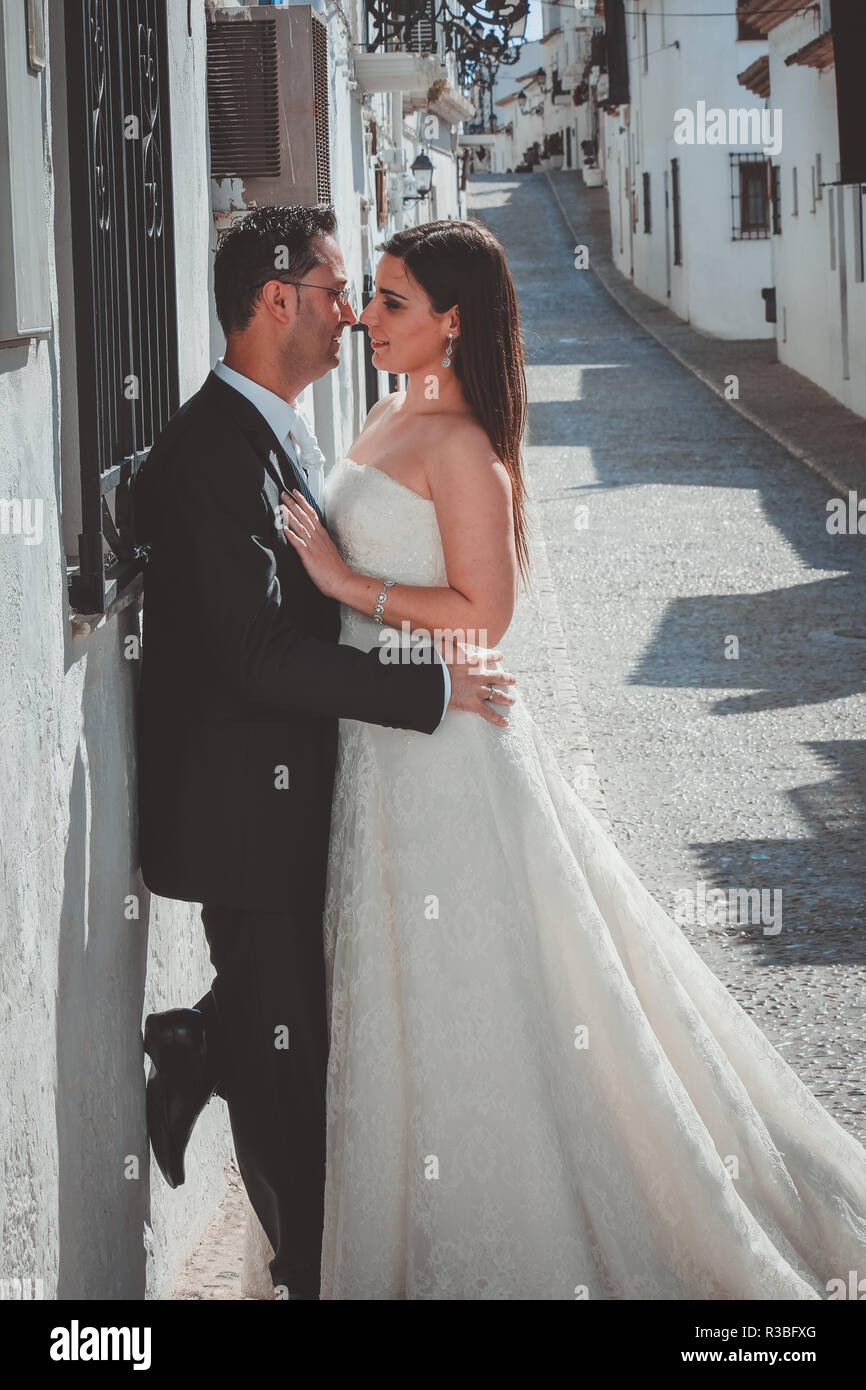 Bride and groom kissing in the street in a mediterranean village Stock ...